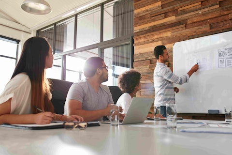 Shot of a male office worker giving creative presentation to his colleagues. Businessman explaining business plan to coworkers in conference room.